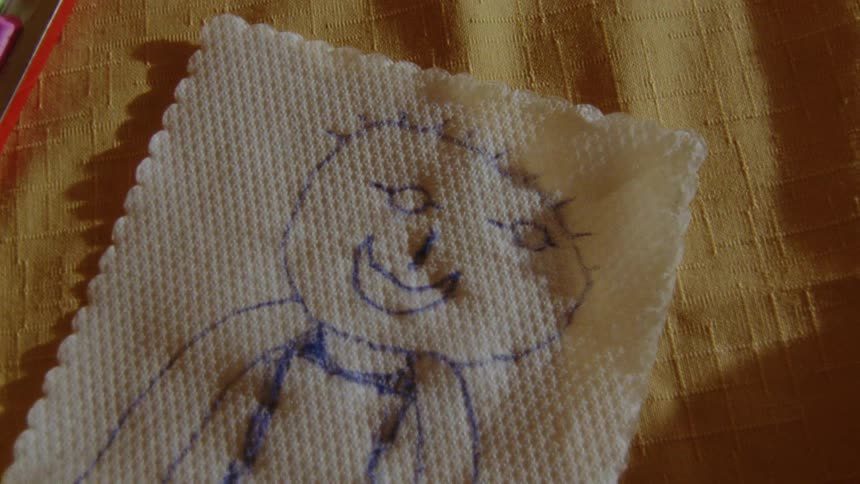 A childlike pen drawing of a person on a piece of cloth