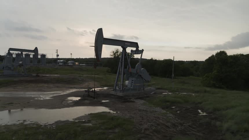 Fast pullback descent past the head of a crude oil pumpjack working on the field