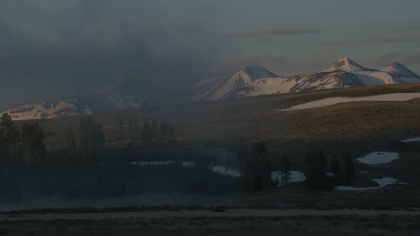 Snow covered mountain peaks with fog settling over the valley in the morning