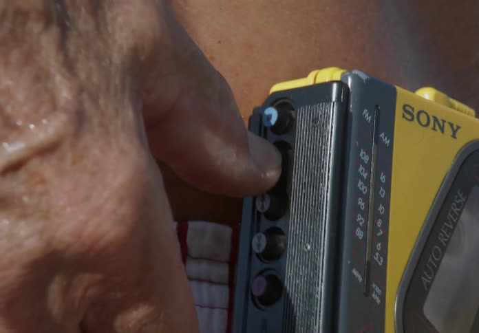 Closeup of a vintage music device on a mans waist which he is adjusting with his hand