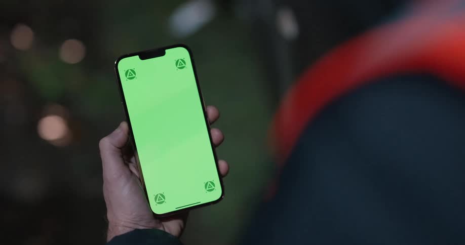 A man looks at his phone while standing on a train