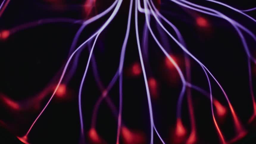 Close up of red and white abstract electrical cords moving around quickly against a dark screen