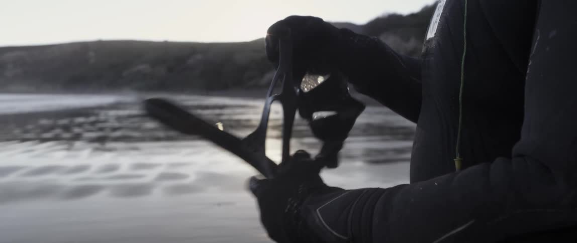 A man examines his goggles and snorkel then puts them on