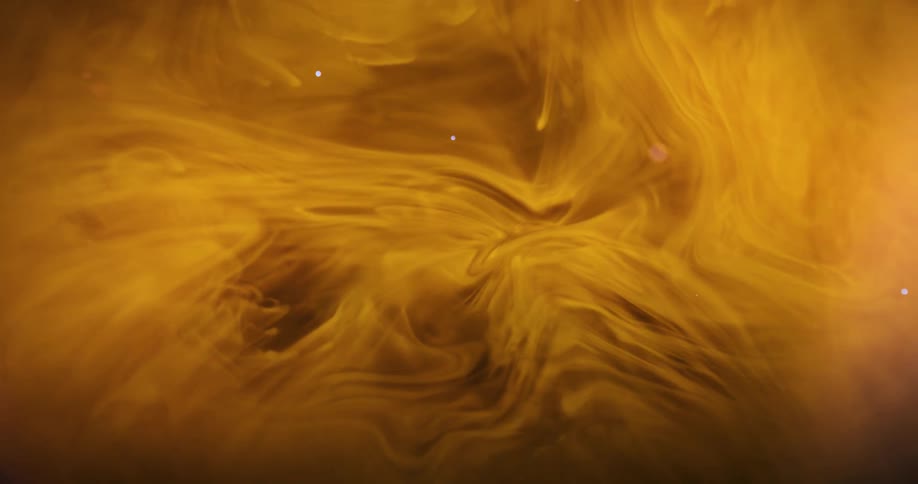 Droplet falling onto a dense yellow and abstract liquid