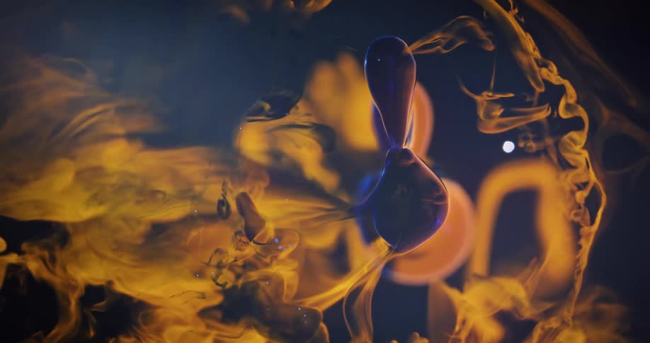 Blue specks move within the morphing barbell shaped bubble floating against gaseous yellow background