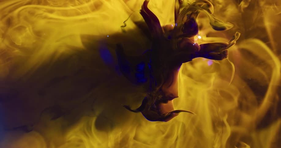 Dense smoke with a predominantly yellow hue and shining black and blue colors creating a suction motion in an abstract manner