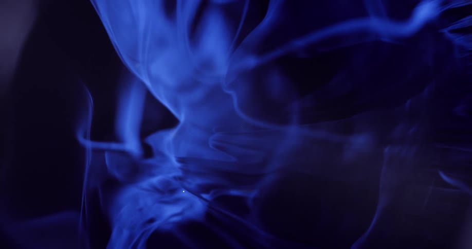 Texture of a droplet falling into blue liquid creating abstract movements on a black background