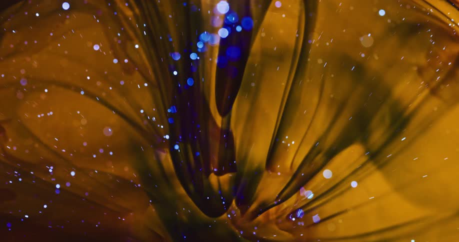 Small explosion of black and bright blue ink within a yellow and abstract liquid