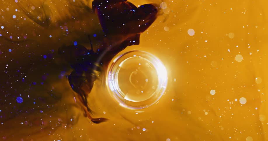 A glass cup floats in glowing water