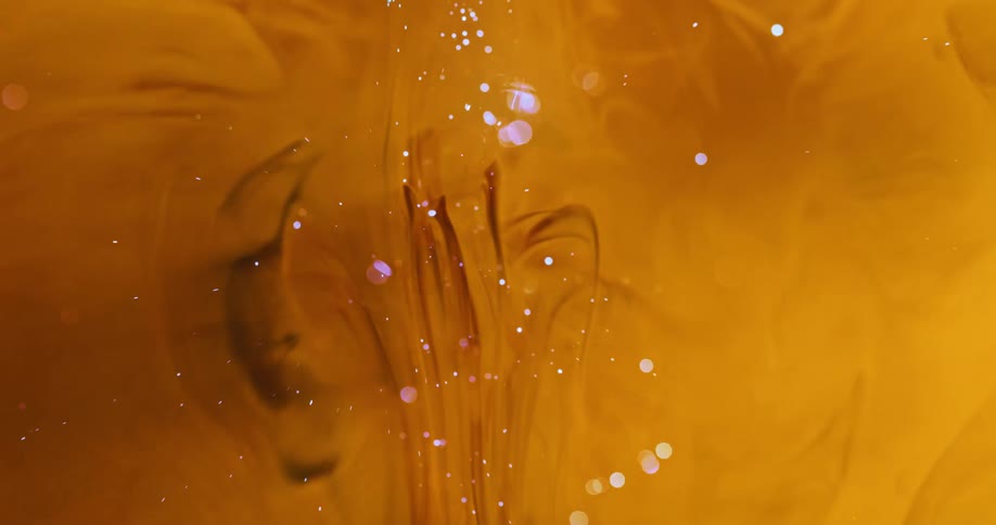 Special and abstract effect of a black drop falling into a shiny yellow liquid