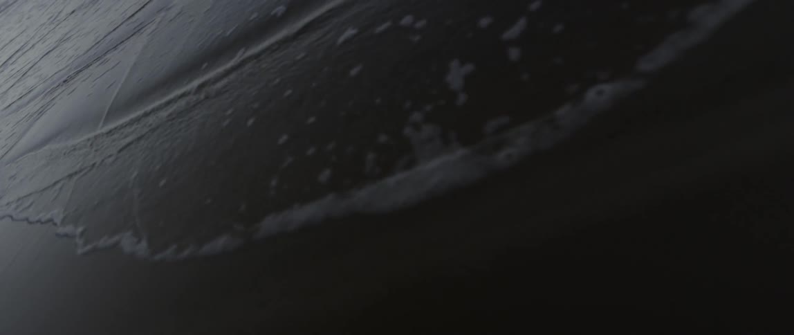Waves move across the sand of a beach below