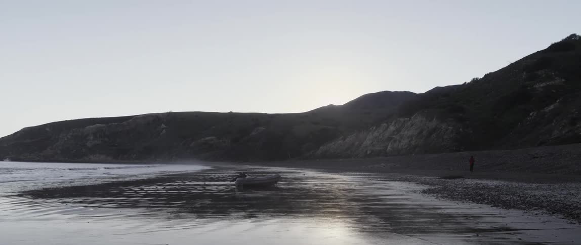 A raft and a person are on the beach