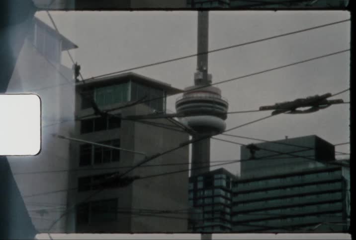 A tower with unique architecture stands out within a city skyline