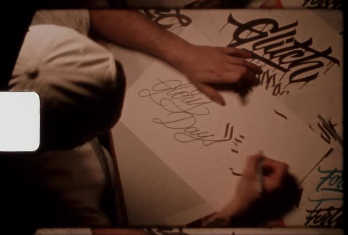Artist drawing on a white sheet with a black pen