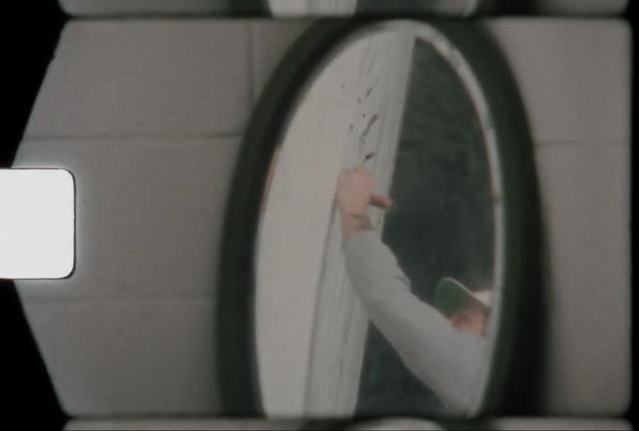 Mirror on the floor showing a man sketching on a white board at midday