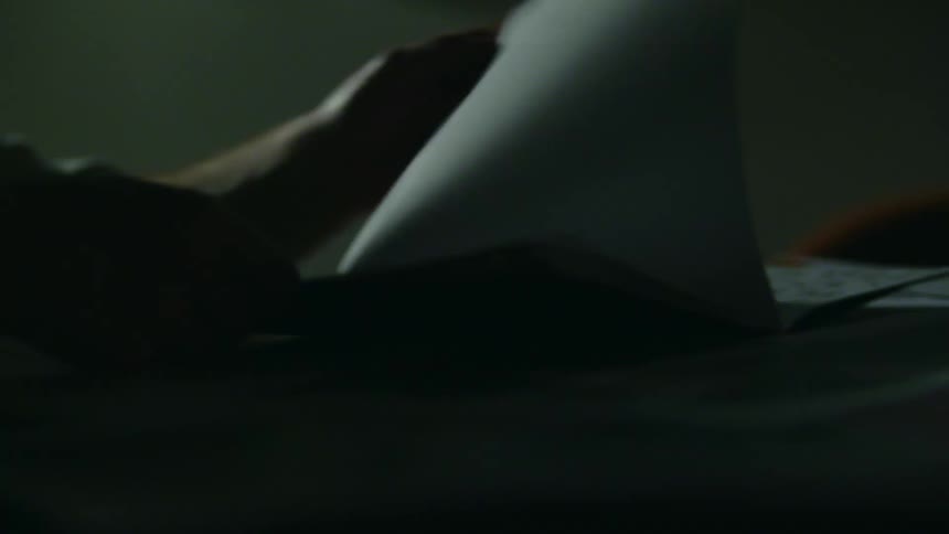 A person turning pages of a book on the table