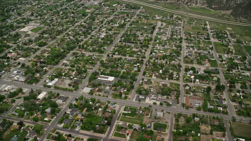 Aerial view of residential neighborhoods orbiting a small suburban town Nephi Utah captured during a cloudy day in the Southwest United States