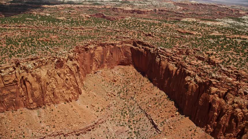  aerial footage showcasing the stunning landscapes of Capitol Reef National Park in Utah featuring red rock cliffs box canyons and mesas topped with trees