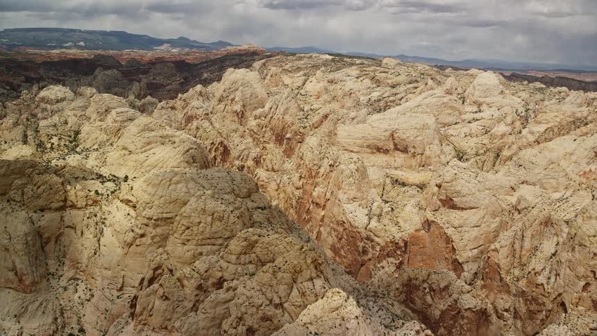  aerial footage showcasing the famous Waterpocket Fold rock formations in Capitol Reef National Park Utah featuring an view of the desert landscape during a partly cloudy day