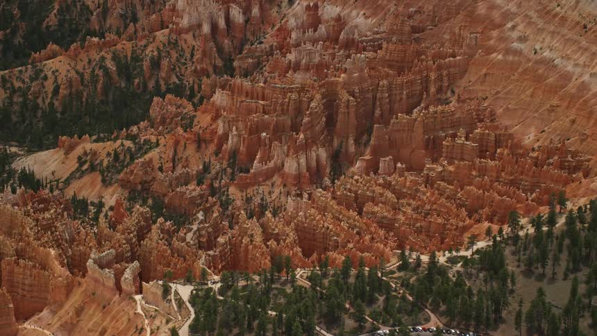 Aerial footage of flying away from hoodoos and buttes revealing the stunning rock formations of Bryce Canyon National Park Utah captured during a sunny day in summer