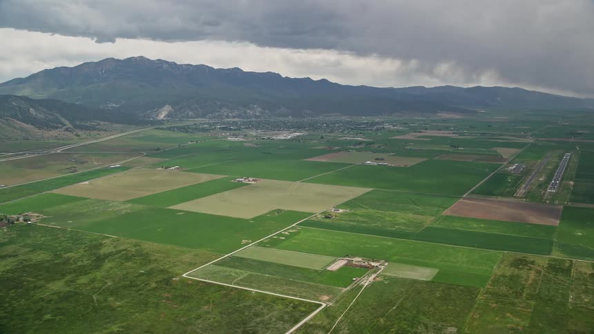 Approaching small rural town and farmland in Nephi Utah with views of the Nephi Municipal Airport and cloudy skies