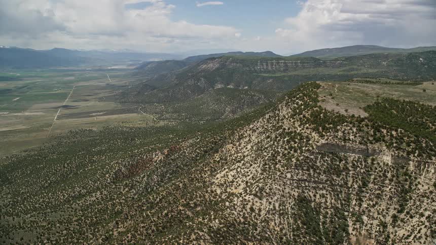Aerial footage of flying over mountain peaks and slopes with trees in the Wasatch Range Utah during summer