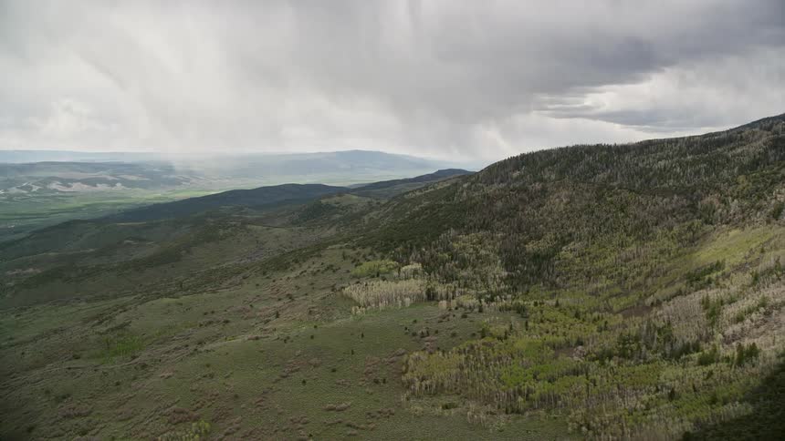 Aerial footage of the mountain range with abundant vegetation featuring aspen and evergreen trees in Fishlake National Forest Utah during a cloudy day in summer