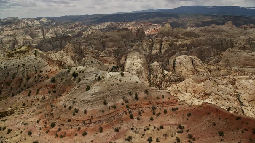 Aerial view of the iconic Waterpocket Fold rock formations in Capitol Reef National Park Utah seen from a mesa on a partly cloudy day during summer