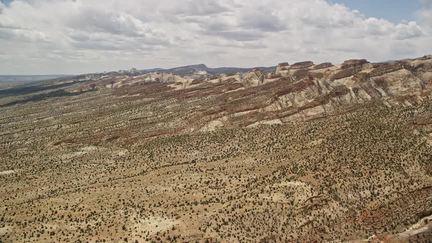 Approaching the majestic Waterpocket Fold rock formations experience the surreal beauty of Capitol Reef National Park from a bird's eye view on a partly cloudy day