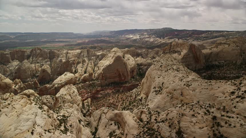 an aerial view of the famous Waterpocket Fold rock formations in Capitol Reef National Park Utah as the footage reveals the stunning desert landscape and approaching the landmark