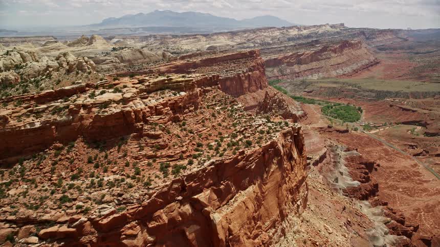 Approaching and revealing a small butte amidst mesa cliffs in Capitol Reef National Park Utah showcasing the stunning rock formations and desert landscape