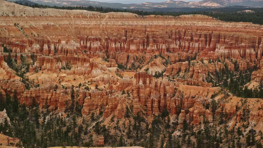Aerial footage of Bryce Canyon National Park showcasing the stunning rock formations hoodoos and buttes on a cloudy day in the arid desert of Utah
