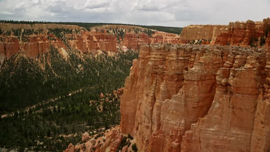 Aerial footage of flying over hoodoos and canyons in Bryce Canyon National Park revealing the stunning natural rock formations and desert landscape of Utah