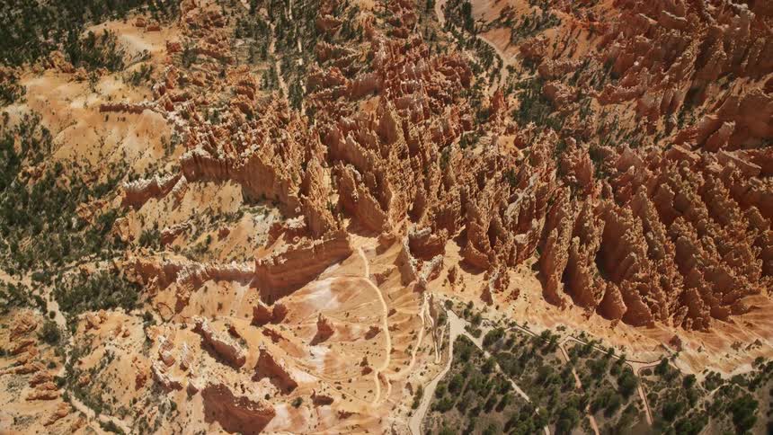 Aerial footage circling around groups of hoodoos and buttes on a cliffside in Bryce Canyon National Park Utah showcasing the famous rock formations and desert landscape