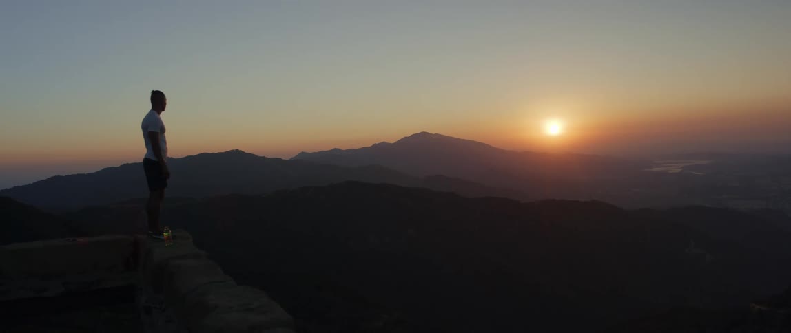 A man watches the sunset on the mountain top