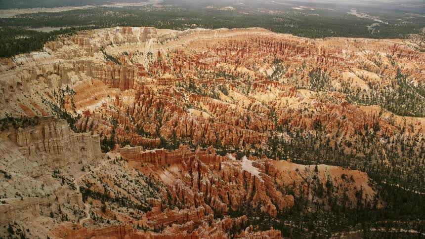 Aerial footage of the iconic hoodoos and buttes in Bryce Canyon National Park Utah showcasing the stunning rock formations and natural beauty on a partly cloudy day