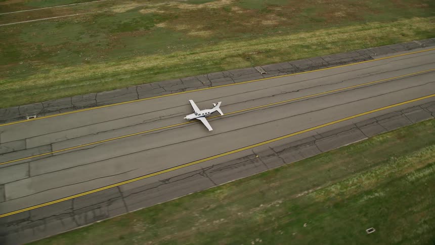 Aerial footage of an airplane taking off from Salt Lake City International Airport in Utah during a partly cloudy day