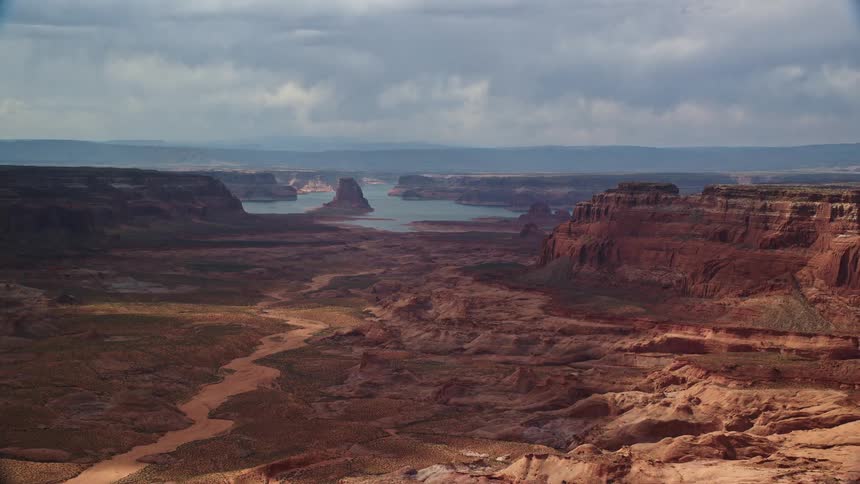 Aerial view of buttes and canyons with Lake Powell in the distance showcasing the natural beauty of the Navajo Nation Reservation in Arizona