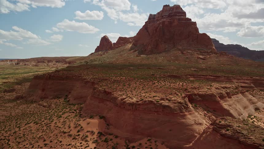 Approaching rock formations and tall buttes in the Navajo Nation Reservation Arizona captured inaerial footage showcasing the arid and natural beauty of the southwest desert landscape