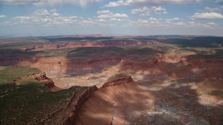 Approaching a red rock canyon and mesas in Navajo Nation Reservation Arizona and Utah on a partly cloudy day during summer in the Southwest United States