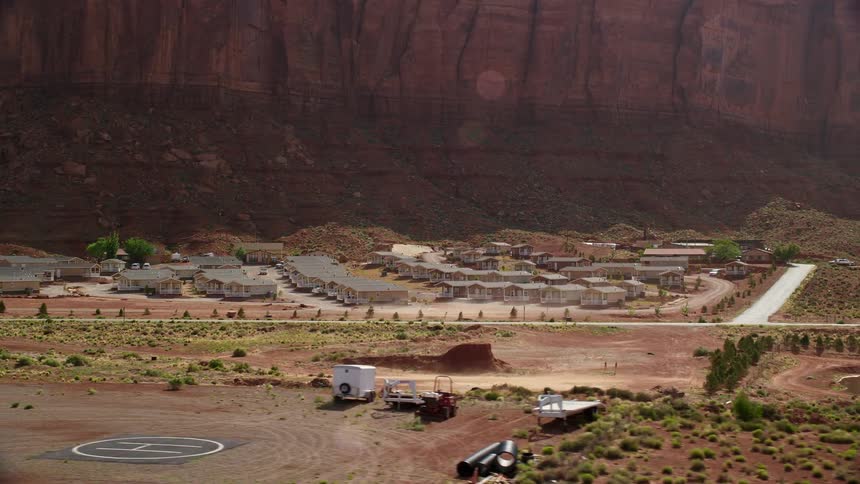  aerial footage of Goulding's Lodge near Monument Valley Airport in Goulding Utah showcasing the stunning desert landscape and small houses with a helipad amidst the canyons