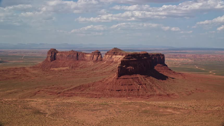  aerial footage captures the stunning brown canyons of Train Rock mesa and the desert valley in the wild flat landscape of the Navajo Nation Reservation Arizona and Utah