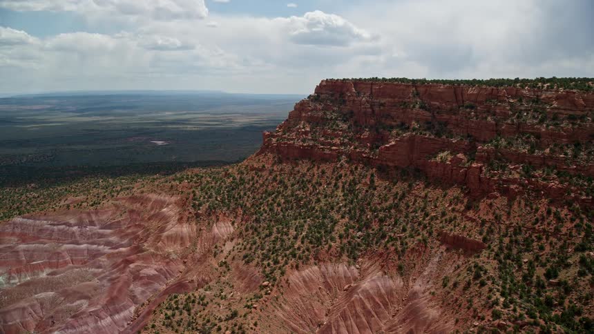 Aerial flyby of mesa rock formations and Glen Canyon National Recreation Area showcasing the natural beauty of the arid desert landscape in Utah and Arizona on a bright sunny day