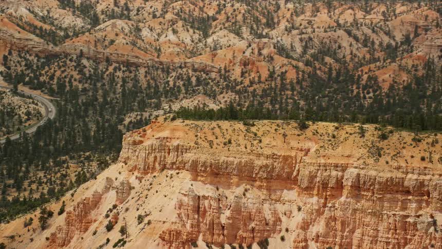 Aerial view of a steep mesa with trees growing on top and through the land in Bryce Canyon National Park Utah
