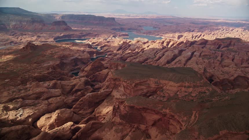 Aerial footage showcasing rock formations in a canyon near Lake Powell Navajo Nation Reservation Utah with a river flowing in the foreground