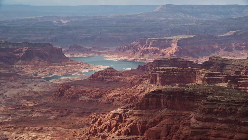 Aerial footage of mesas bordering Lake Powell on the Navajo Nation Reservation in Utah showcasing the natural beauty of the arid landscape and water body