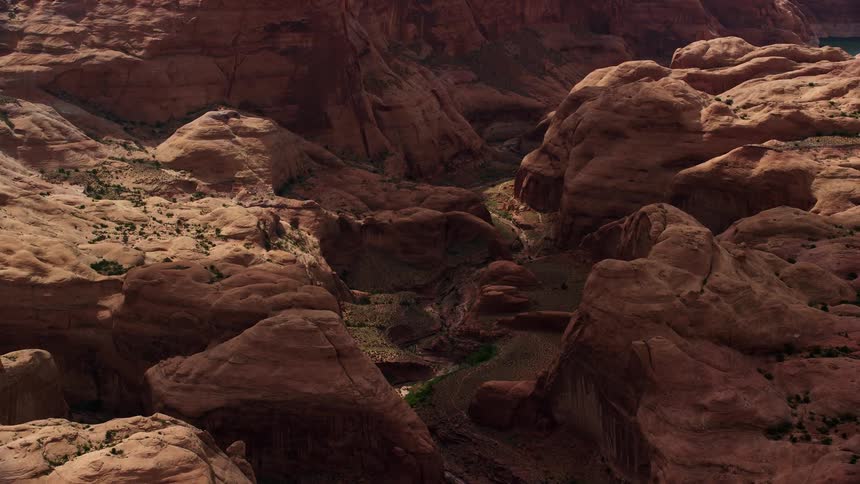  aerial footage of a stone arch in Rainbow Bridge National Monument Utah captured during a partly cloudy day in the arid desert landscape of the Southwest showcasing the unique rock formations and tribal lands of the Navajo Nation Reservation