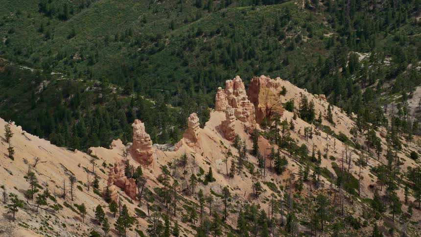 Aerial footage showcasing the stunning rock formations and forested valley of Bryce Canyon National Park in Utah with partly cloudy skies