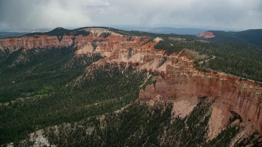 Approaching and flyby of iconic rock formations the Pink Cliffs in Bryce Canyon National Park Utah showcasing the famous striations and limestone structures during a partly cloudy day time