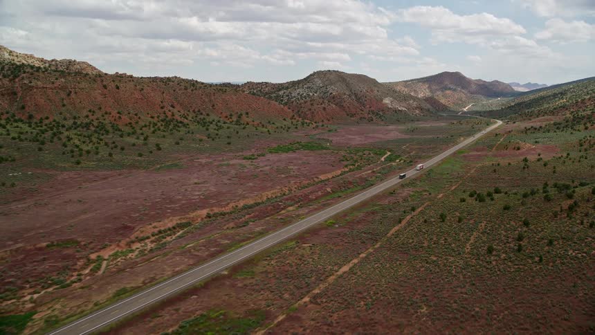 Aerial footage of vehicles traveling on Highway 89 through the desert landscape of Glen Canyon National Recreation Area in Utah and Arizona during summer